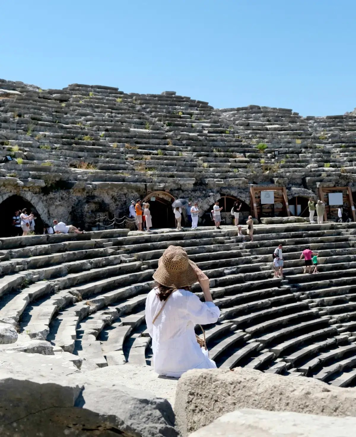 Tourist taking photo at an ancient Roman amphitheater.